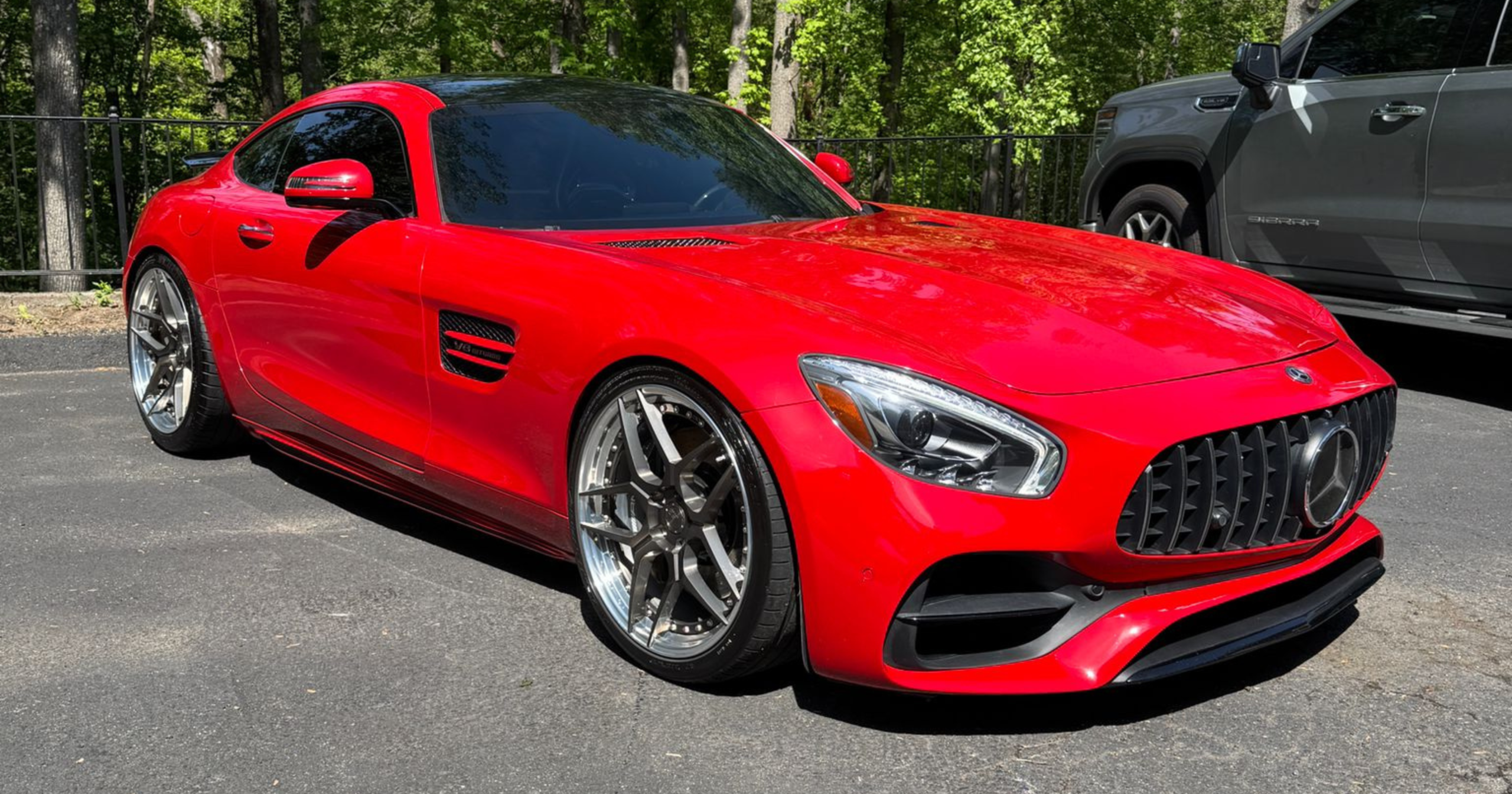 A bright red Mercedes-Benz AMG GT parked outside, demonstrating the flawless, swirl-free finish required before applying a true ceramic coating to avoid the $199 ceramic coating scam.