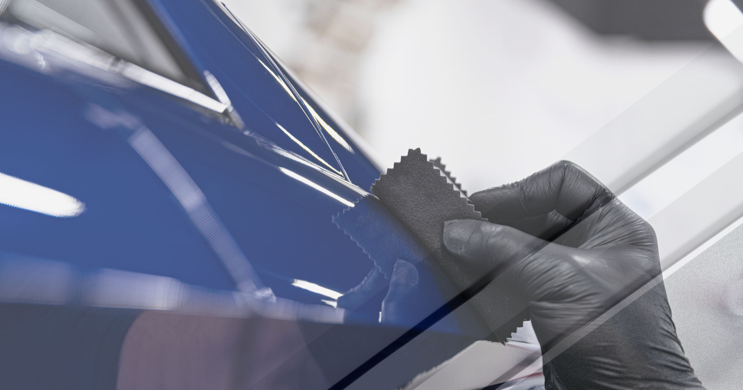 A detailer wearing black gloves applying product with a microfiber applicator to a blue vehicle panel, demonstrating the careful application process required in Baltimore to avoid the $199 ceramic coating scam.