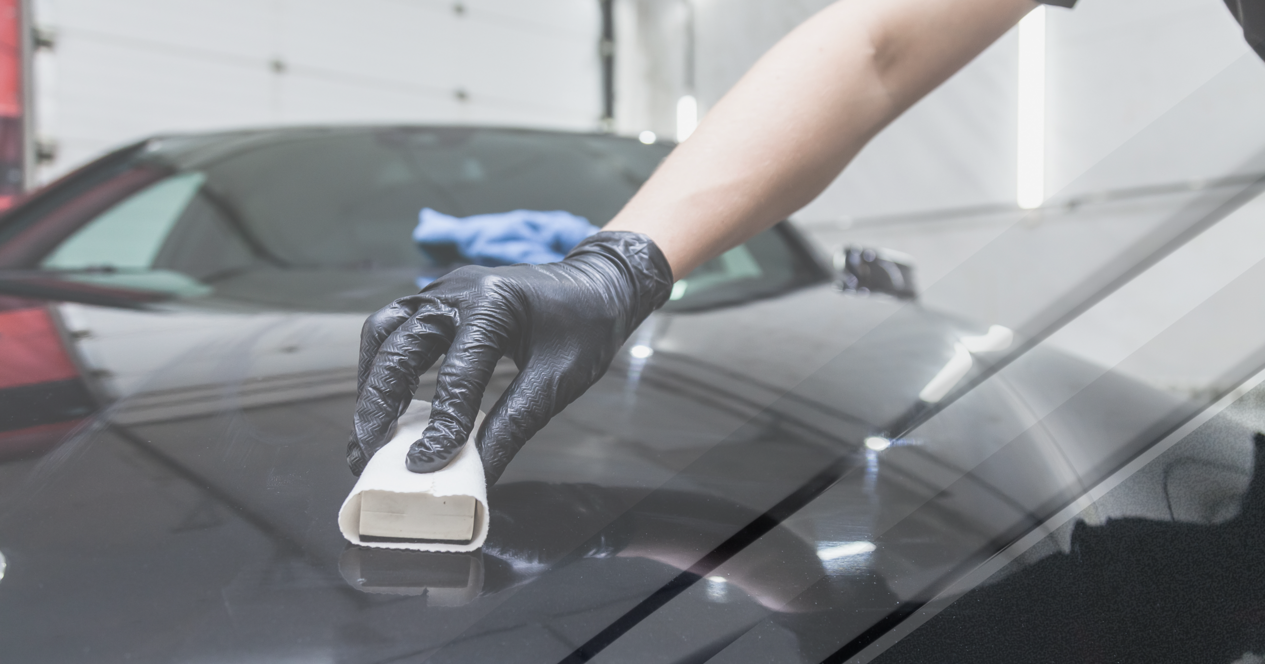An authorized installer wearing black gloves carefully applying ceramic glass coating to the hood of a black vehicle, illustrating the professional installation process in Maryland that solves the $199 ceramic coating scam.